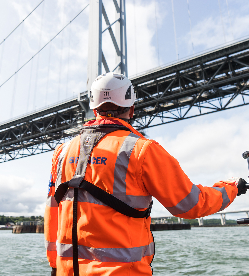 Spencer Group engineer standing beneath bridge infrastructure