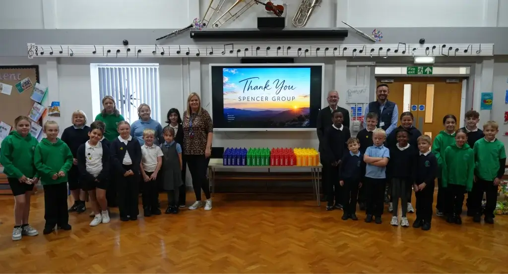 Charlie Spencer and Daniel Wilson stood with teachers and children from Longhill Primary School
